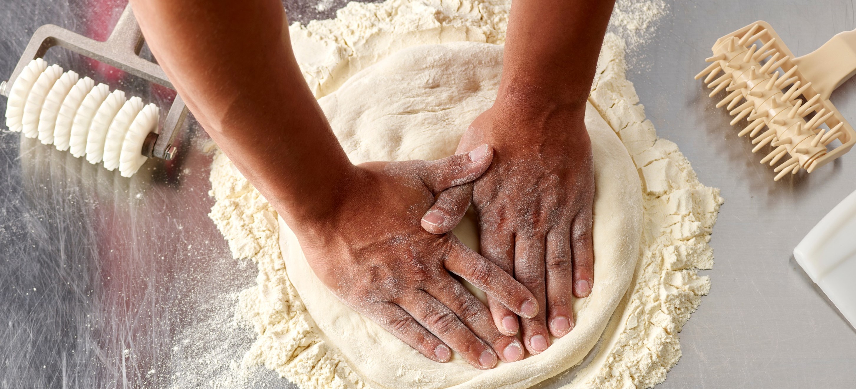 Papa Johns team member rolls dough