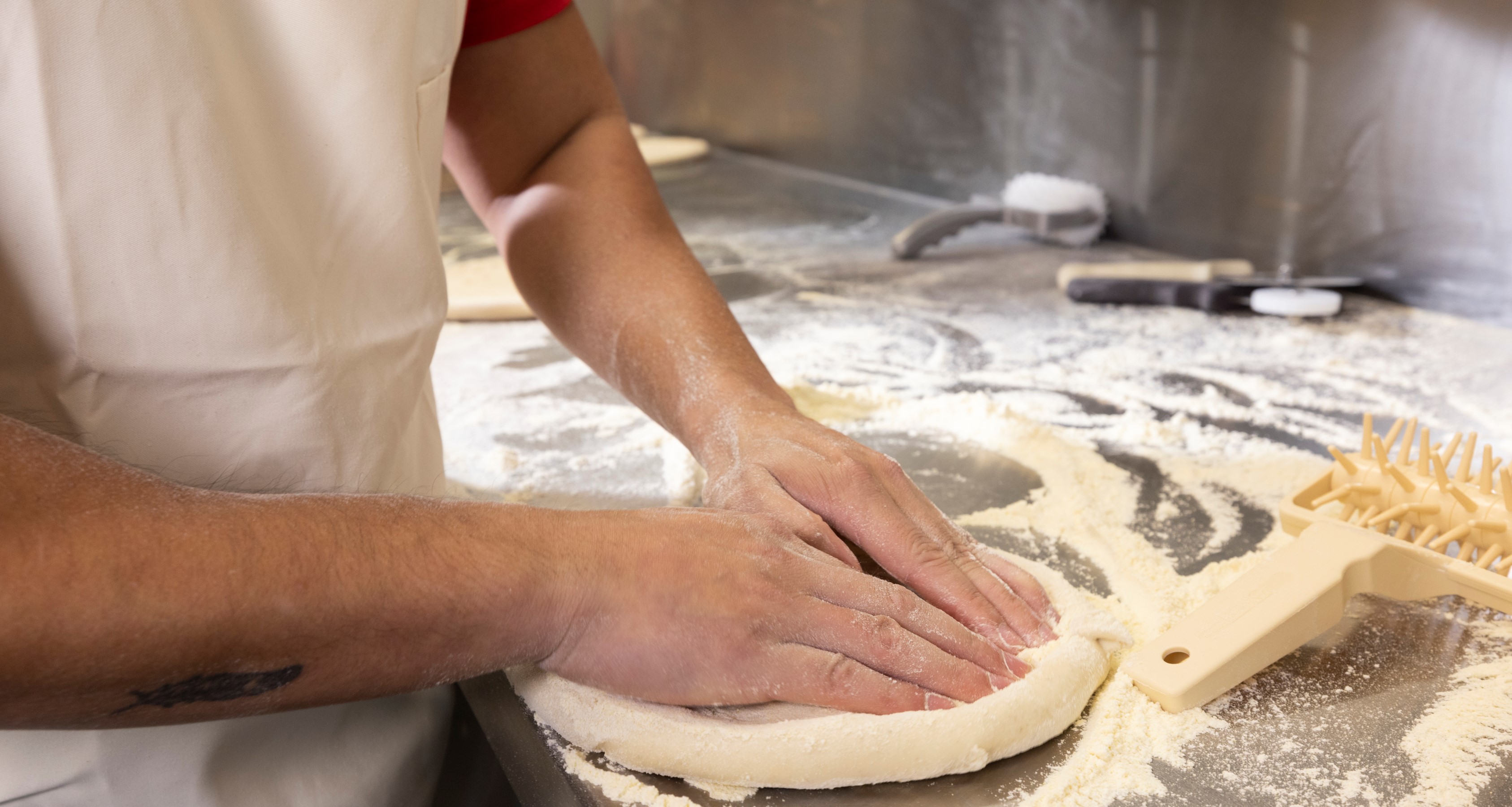 A person's hands preparing a pizza