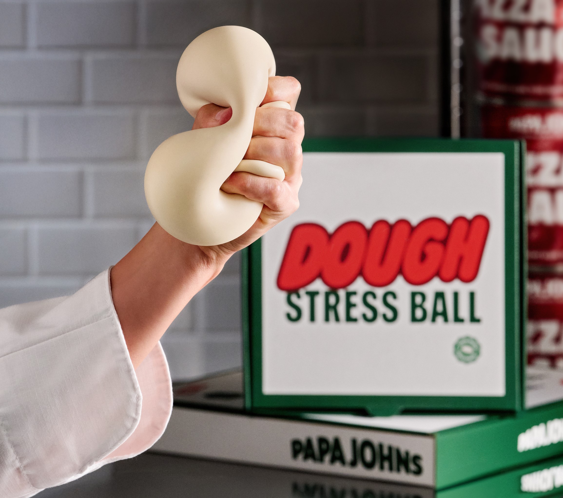 A hand squeezing a dough stress ball