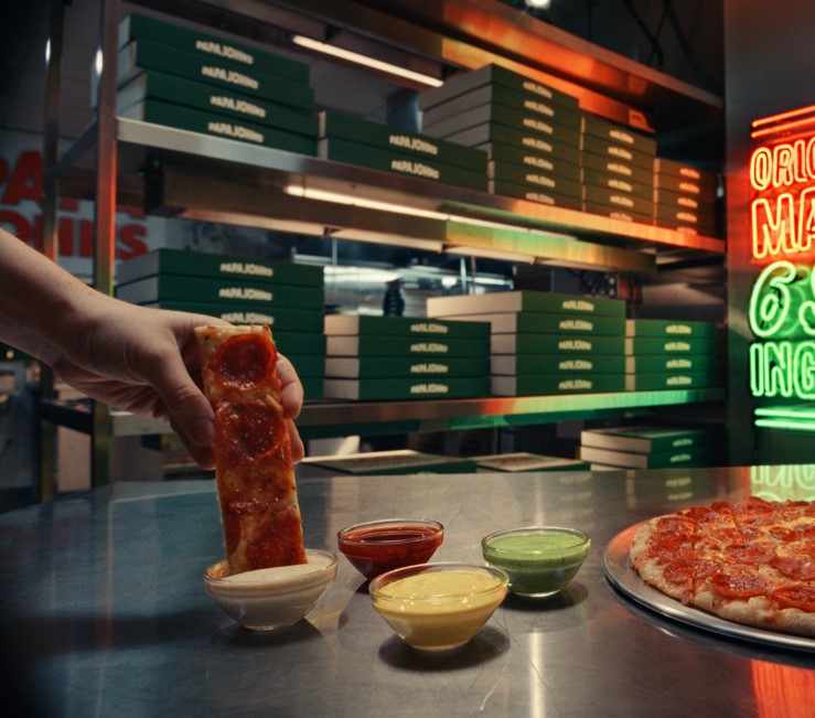 Pizza being dipped into garlic dip