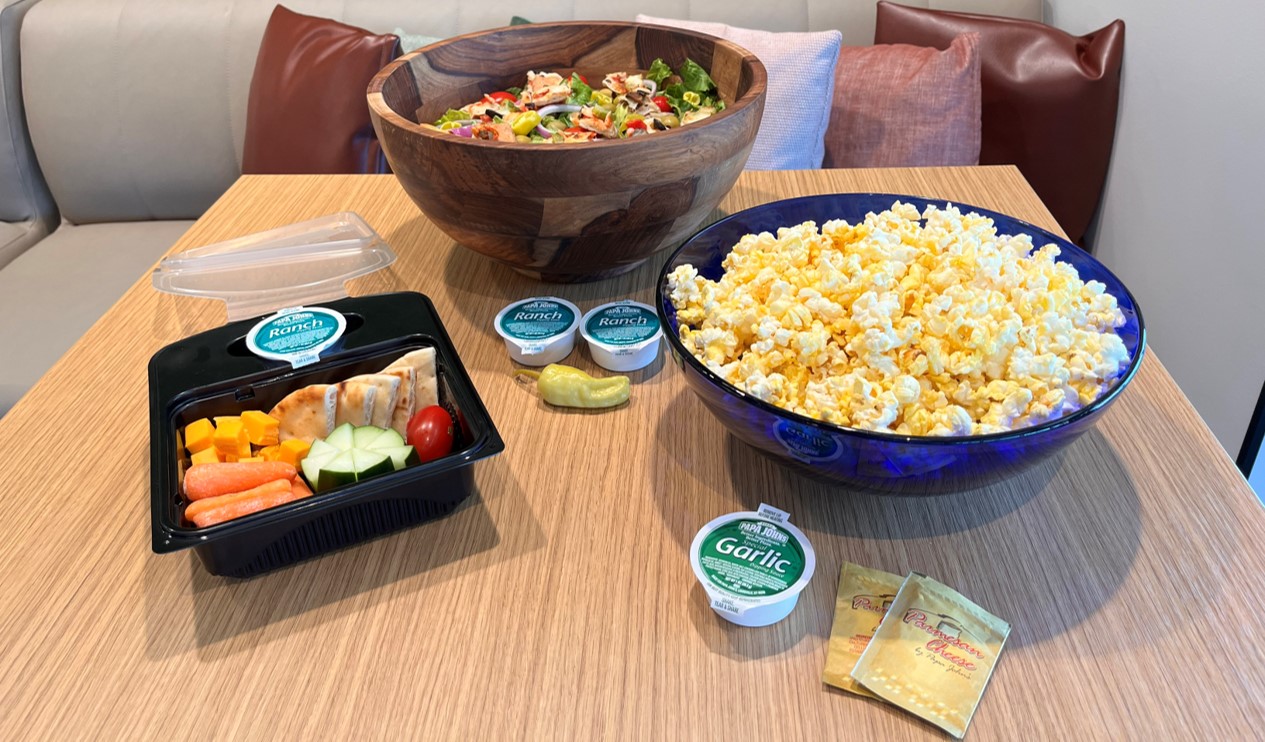 Lunch box, salad and bowl of popcorn