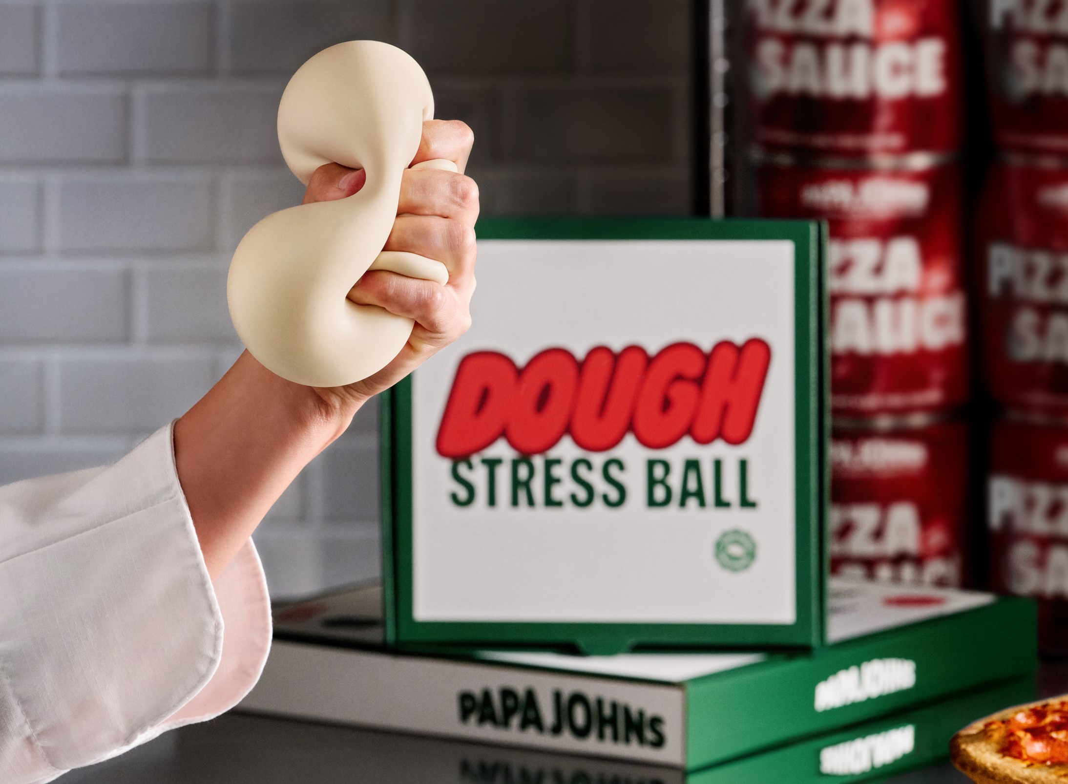 A hand squishing a dough stress ball