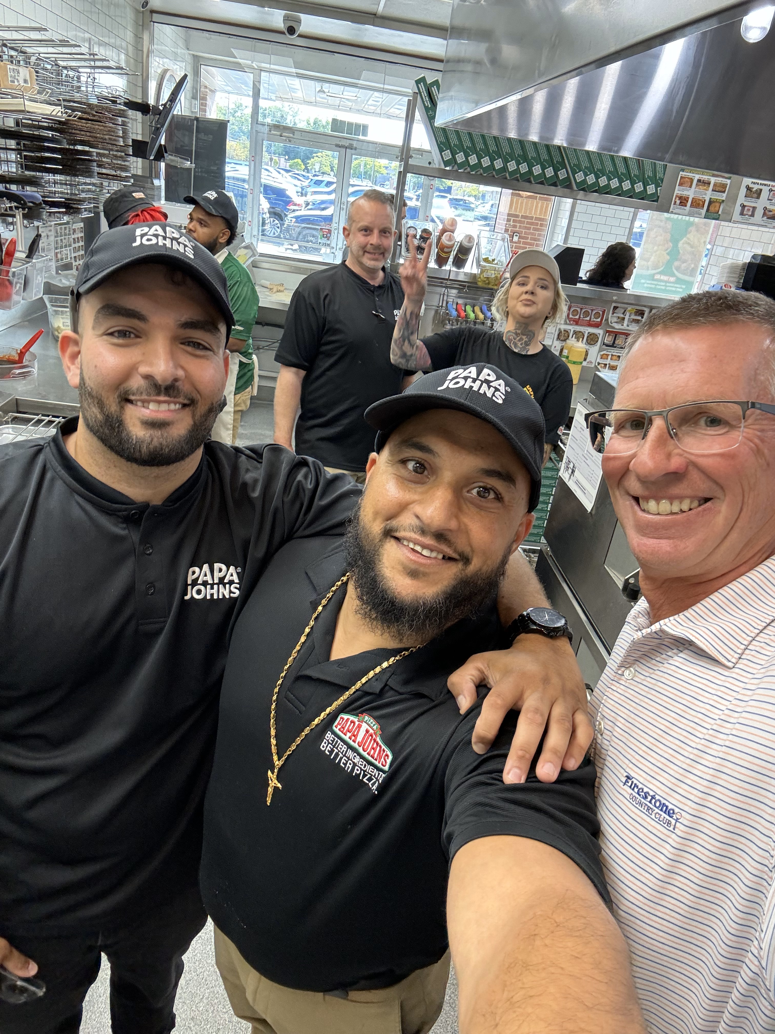 Todd meets with team members inside a Papa Johns restaurant