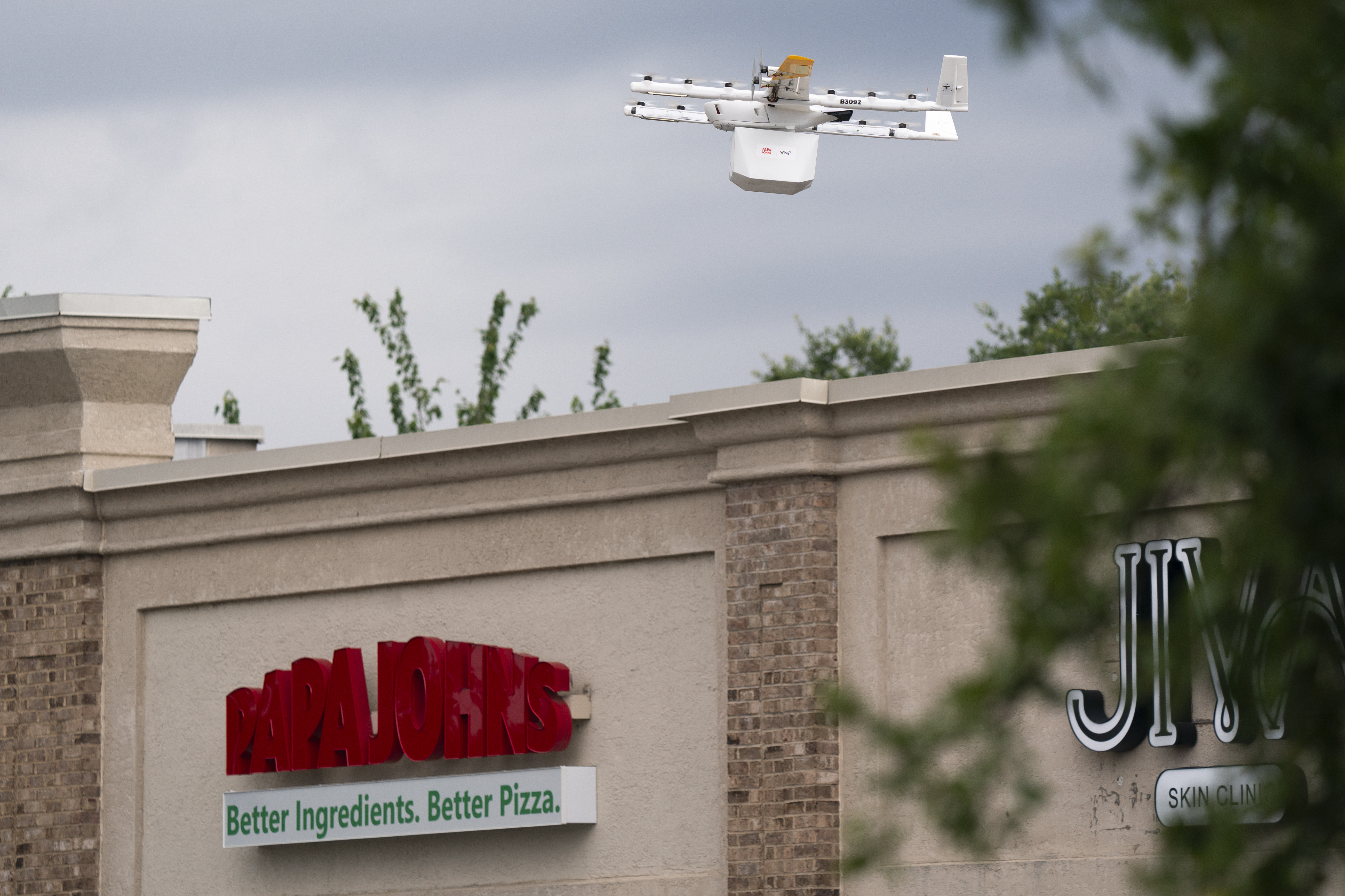 A drone carrying a Papa Johns order flying through the air