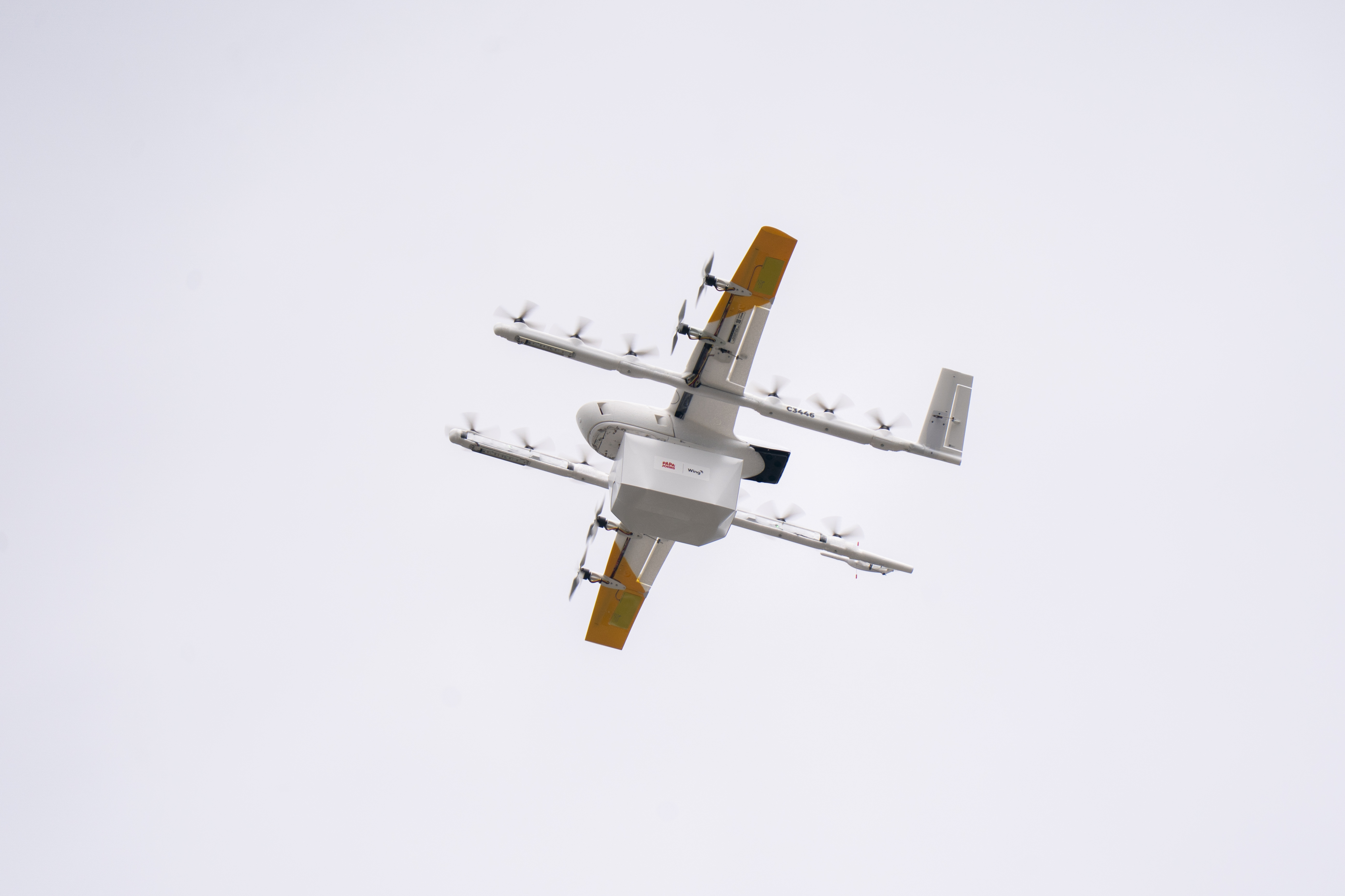 A drone carrying a Papa Johns order flying through the air
