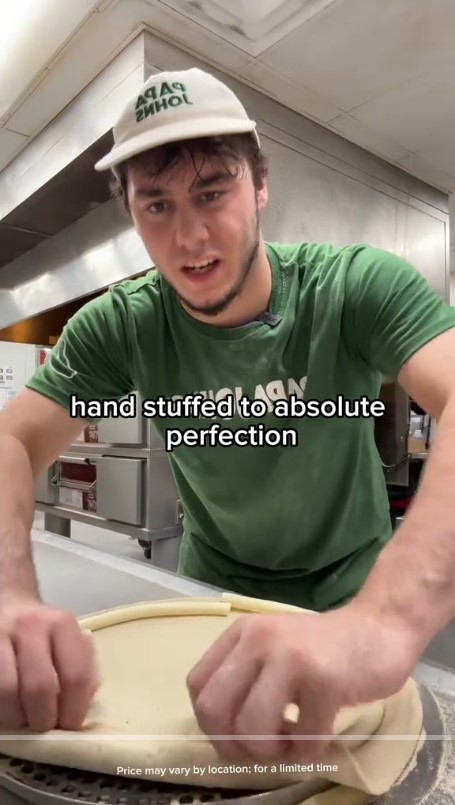 A man preparing a Papa Johns pizza