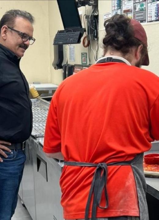 Nadeem Bajwa observes a pizza being made