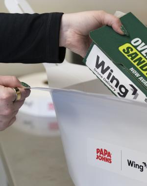 A Papa Johns sandwich being placed into a box for delivery via drone