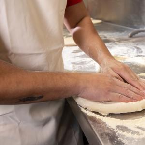 Hands rolling dough