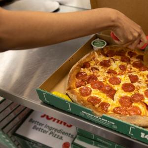 Papa Johns team member cutting a pizza