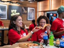 A group of students enjoying pizza.