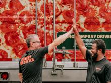 Two Papa Johns team members giving a high-five