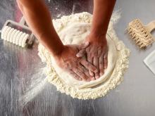 Hands rolling dough