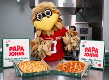 Freddie Falcon poses with Papa Johns pizzas.