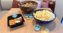 Lunch box, salad and bowl of popcorn