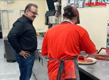 Nadeem Bajwa observes a pizza being made