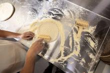 Hands rolling dough