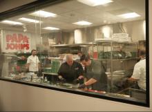 People making pizzas inside the Papa Johns test kitchen