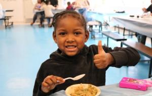 Young girl happily eating