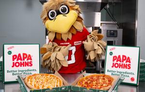 Freddie Falcon poses with Papa Johns pizzas.