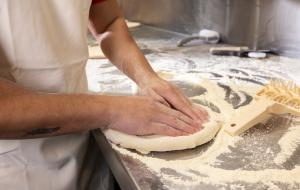 A person's hands preparing a pizza