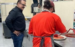 Nadeem Bajwa observes a pizza being made