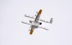 A drone carrying a Papa Johns order flying through the air