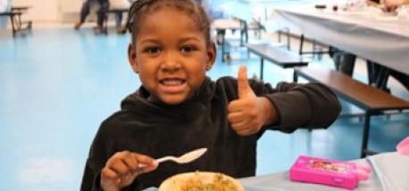 Young girl happily eating