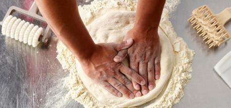 Hands rolling dough