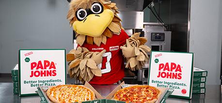 Freddie Falcon poses with Papa Johns pizzas.