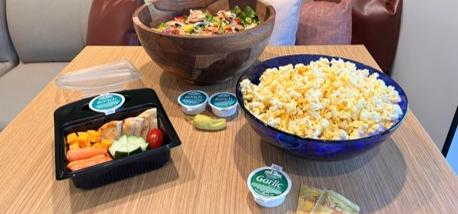 Lunch box, salad and bowl of popcorn