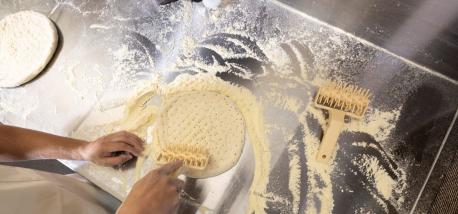 Hands rolling dough