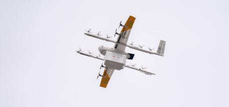 A drone carrying a Papa Johns order flying through the air