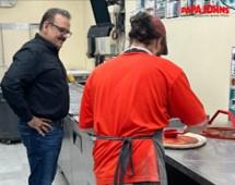 Nadeem Bajwa observes a pizza being made