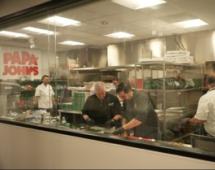 People making pizzas inside the Papa Johns test kitchen
